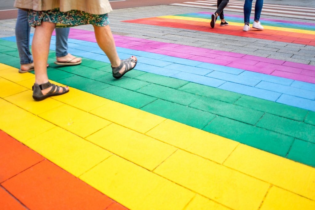 four people walking on multicolored striped pavement